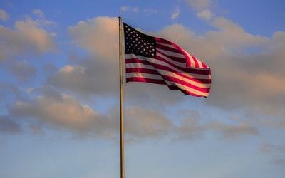 美国国旗在白天多云的天空下
